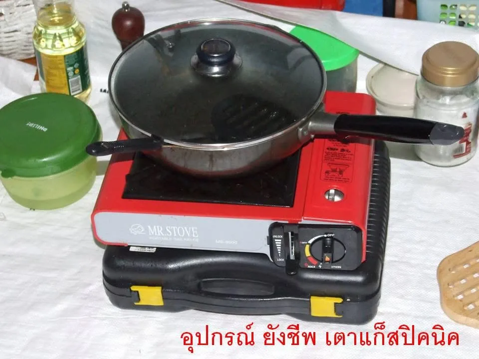 เตาแก๊สปิกนิกพร้อมกระทะวางบนโต๊ะ